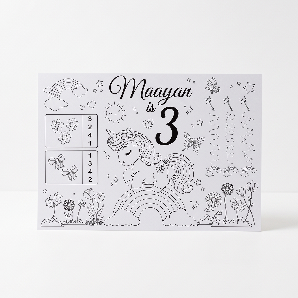 A personalized first birthday coloring card for a girl named Maayan, featuring a black and white unicorn, rainbow, sun, flowers, and counting boxes on a white background.
